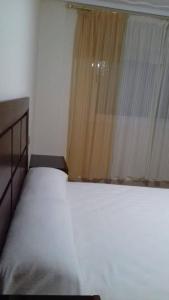 um quarto com uma cama branca e uma janela em إقامة للعطلة على بعد 200 متر من البحر em Nador
