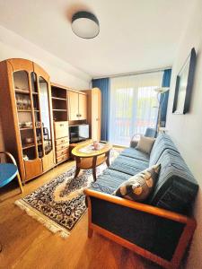 een woonkamer met een bank en een tafel bij Apartament Rodzinny RETRO Górska Holdimex by RentiloPL in Szczyrk