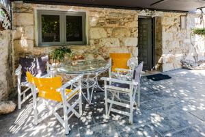 a patio with a glass table and chairs at Stone House in Athens