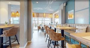 a restaurant with a bar with chairs and tables at Seaside-Strandhotel in Timmendorfer Strand