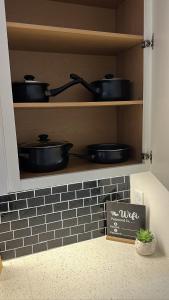 a shelf with pots and pans in a kitchen at The Refuge Retreat in Fort Worth