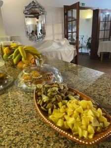 a bowl of fruit on a counter with a plate of food at Terra Luso Proche De Montejunto in Cadaval