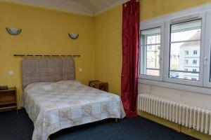 Schlafzimmer mit einem Bett und einem Fenster in der Unterkunft Hôtel de la cloche in Vitry-le-François