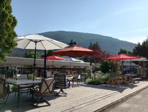 a patio with tables and chairs and umbrellas at Magnuson Hotel Creston in Creston