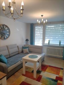 een woonkamer met een bank en een tafel bij Apartament ALE LABA in Kołobrzeg