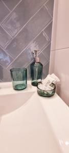 - une salle de bains avec 2 bouteilles de savon sur un lavabo dans l'établissement Ostoja Struga, à Świnoujście