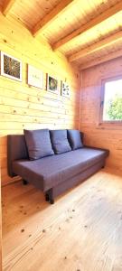 a couch in a log cabin with a window at Ostoja Struga in Świnoujście