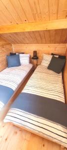 2 łóżka w domku z drewnianym sufitem w obiekcie Ostoja Struga w Świnoujściu
