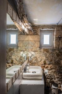 a stone bathroom with two sinks and two windows at Stone House in Athens