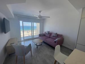 uma sala de estar com um sofá roxo e uma mesa em Medi Playa primera linea con piscina em Calpe