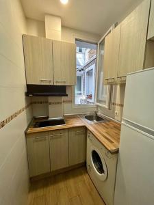 eine Küche mit einer Waschmaschine, einer Spüle und einem Kühlschrank in der Unterkunft Atocha Ferrocarril 5 in Madrid