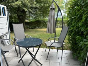 a table and chairs and an umbrella on a patio at Ferienwohnung in Oberschondorf mit Terasse in Schondorf am Ammersee