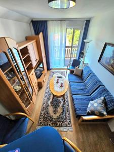 een woonkamer met een blauwe bank en een tafel bij Apartament Rodzinny RETRO Górska Holdimex by RentiloPL in Szczyrk
