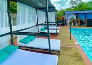 un grupo de camas sentado junto a una piscina en Llano Dorado Hotel Campestre, en Villavicencio