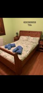 una cama de madera con 2 almohadas encima en Casa Ángeles, en Nueva de Llanes