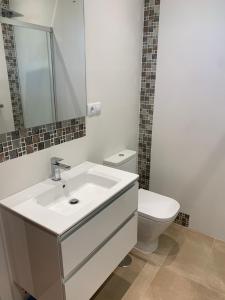 a bathroom with a white sink and a toilet at Casa Ángeles in Nueva de Llanes +16 photos