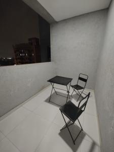 卡塔馬卡的住宿－Temporario catamarca，窗户客房内的两把椅子和一张桌子