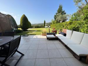 a patio with a couch and a table and chairs at Angelo’s Elegant Summer House in Possidi