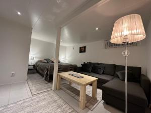 een woonkamer met een bank en een tafel bij Nyrenoverat boende i villaområde in Gävle
