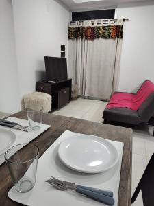 a table with a white plate on top of it at Temporario catamarca in San Fernando del Valle de Catamarca