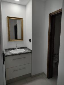 een badkamer met een wastafel en een spiegel bij Temporario catamarca in San Fernando del Valle de Catamarca