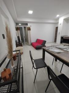 een woonkamer met een tafel en stoelen en een bank bij Temporario catamarca in San Fernando del Valle de Catamarca