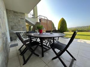 a wooden table and chairs on a patio at Angelo’s Elegant Summer House in Possidi