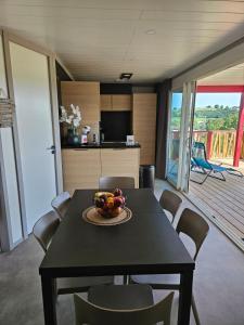 un comedor con una mesa con un bol de fruta. en Chalet avec piscine, climatisation & vue de 2 à 6 personnes - Hasparren - Pays Basque - Chalet Ibaia en Hasparren