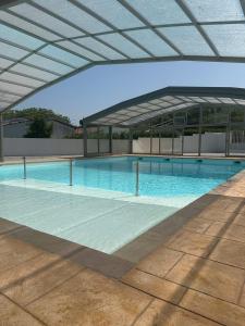 una gran piscina con un edificio en el fondo en Chalet avec piscine, climatisation & vue de 2 à 6 personnes - Hasparren - Pays Basque - Chalet Ibaia en Hasparren