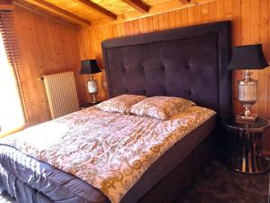 Chalet Bellevue, Villars-sur-Ollon في Ollon: غرفة نوم بسرير كبير ومصباحين