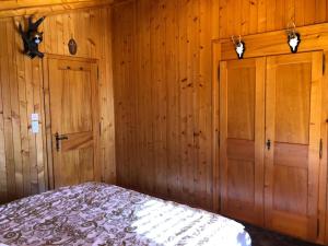 una camera da letto con pareti rivestite in legno e un letto di Chalet Bellevue, Villars-sur-Ollon a Ollon