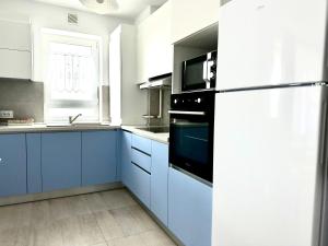 een keuken met blauwe kasten en een zwarte koelkast bij 4FriendsCoresiBrasov Blue in Braşov