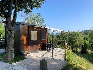 a black tiny house with a table on a deck at I Falchi Pellegrini - Bungalow e Tenda in Monzuno