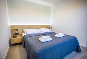 um quarto com uma cama azul com duas toalhas em Villa Favi em Pakoštane