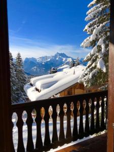 Chalet Bellevue, Villars-sur-Ollon في Ollon: شرفة مغطاة بالثلج مطلة على الجبل