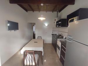 a small kitchen with a white refrigerator and a table at Departamento sierras Balcarce in Balcarce