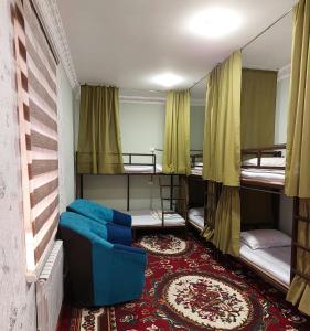a room with three bunk beds and a couch at Hostel.Uz in Samarkand