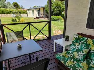 a patio with a couch and a table on a deck at Naturalayos con jacuzzi privado in Pelayos de la Presa