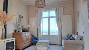 Hautot-sur-Mer的住宿－La déferlante, Magnifique villa vue sur mer à Pourville，客厅设有大窗户和沙发