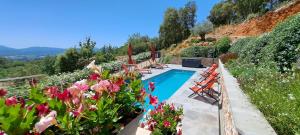 a swimming pool in a garden with flowers at Les Hauts Du Peireguier in La Motte