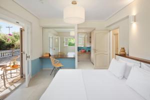 una camera con un grande letto bianco e una cucina di Ionian Garden Villas - Villa Pietra a Benitses Altre 64 foto
