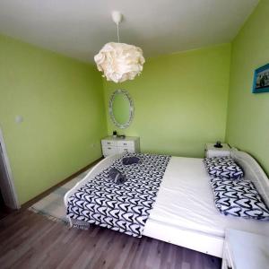 a bedroom with a large bed in a green wall at "House of swallows" vacation home, close to Sofia in Makotsevo