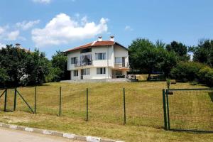 a house on a field with a fence at "House of swallows" vacation home, close to Sofia in Makotsevo