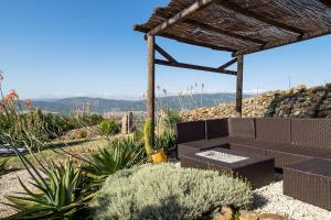 un jardín con un banco y una pared de piedra en El Refugio del Viento, Casita Levante, en Facinas