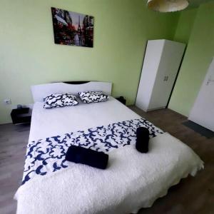 a bedroom with a large white bed with black and white pillows at "House of swallows" vacation home, close to Sofia in Makotsevo