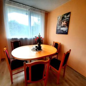 a dining room table and chairs with a vase of flowers on it at "House of swallows" vacation home, close to Sofia in Makotsevo +49 photos