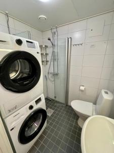 - un lave-linge dans la salle de bains pourvue de toilettes dans l'établissement Hogland Apartments - 2, à Kotka