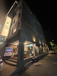 沐-湯宿溫泉行旅 في جياوكسي: مبنى أمامه جلسة في الليل