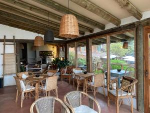 a dining room with tables and chairs and windows at Posada Portal del Sol in Maitencillo