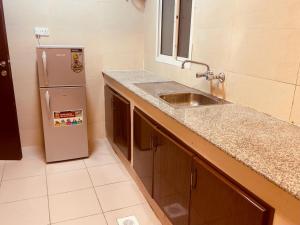 a kitchen with a sink and a refrigerator at Star Emirates Inn in Salalah